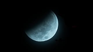 The Earth's shadow begins to fall on the moon during a total lunar eclipse, as seen above Miami, Wednesday, Oct. 8, 2014