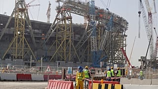 File photo: Workers walk to the Lusail Stadium, one of the 2022 World Cup stadiums, in Lusail, Qatar