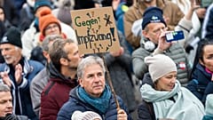 A demonstrator holds a placard reading 'Against compulsory vaccination' during an anti-vaccination protest at the Ballhausplatz in Vienna, Austria