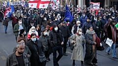 Demonstrators hold Georgian national and EU flags as they march during a rally in support of former President Mikheil Saakashvili in Tbilisi, Georgia, Friday, Nov. 19, 2021. 