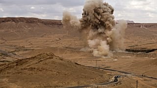 دخان يتصاعد فوق لغم أرضي تم تفجيره في بلدة تدمر الأثرية بمحافظة حمص الوسطى ، سوريا. 2021/04/14