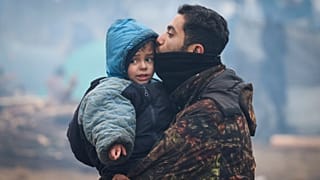 رجل يقبل ابنه عند حدود بيلاروس-بولندا 