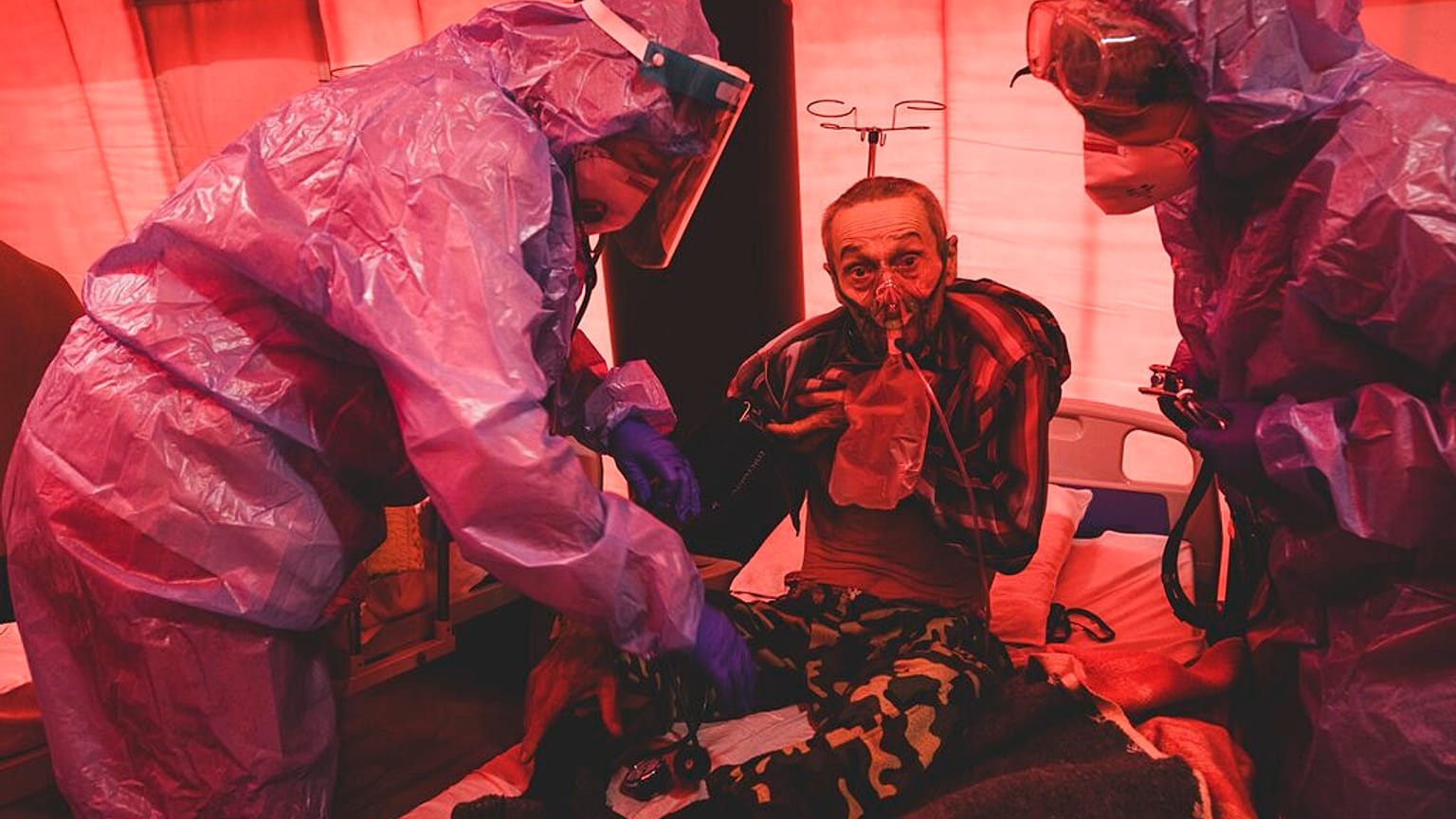 Medical staff treat a coronavirus patient in tents, erected adjacent to a hospital in the city of Kakhovka, Ukraine, on Sunday, Oct. 31, 2021.
