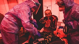 Medical staff treat a coronavirus patient in tents, erected adjacent to a hospital in the city of Kakhovka, Ukraine, on Sunday, Oct. 31, 2021.