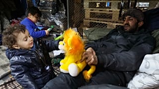 Иракский беженец в детьми в центре размещения мигрантов близ КПП "Кузница" на белорусско-польской границе