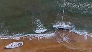Sailboats used by smugglers to transport migrants are beached on Le Cannelle beach in Isola Capo Rizzuto, Calabria region, Southern Italy