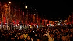 Spectators gather to attend the Champs Elysee Avenue illumination ceremony for the Christmas season, in Paris, Sunday, Nov. 21, 2021.