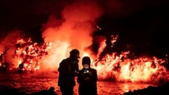 Scientists take geophysics measurements as lava flows from a volcano reaching the sea on the Canary island of La Palma, Spain, Thursday, Nov. 11, 2021