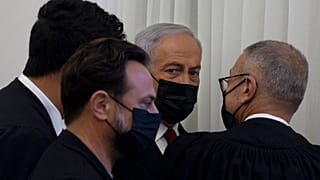 Former Israeli Prime Minister Benjamin Netanyahu, third from left, is flanked by lawyers before testimony by star witness Nir Hefetz, a former aide, in his corruption trial at