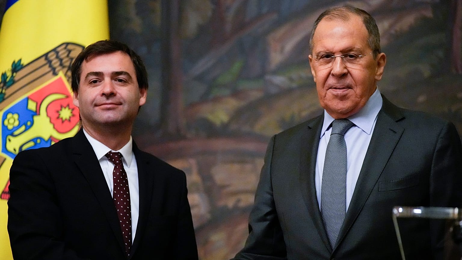 Russian Foreign Minister Sergey Lavrov, right, and his Moldovan counterpart Nicu Popescu shake hands 17 November 2021.