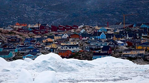 floating ice, left over from broken-up icebergs shed from the Greenland ice sheet, nearly cover the seafront in Ilulissat, Greenland.