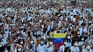 Members of the National Orchestra System raise their instruments after they played a 12-minute Piotr's Slavic March Ilich Tchaikovsky in Caracas, Venezuela, on Nov. 13, 2021.