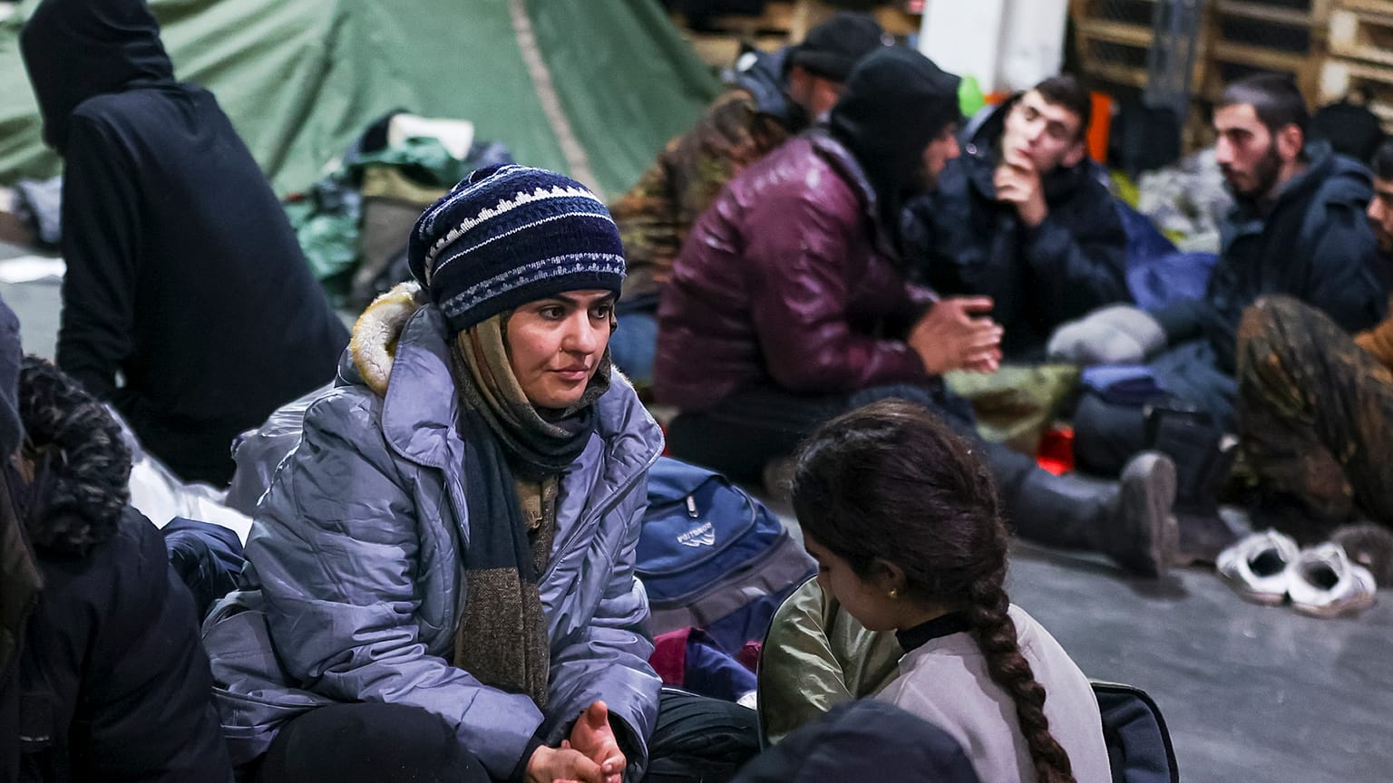 Des migrants se reposent dans un centre logistique au checkpoint "Kuznitsa" à la frontière Bélarus-Pologne près de Grodno (Bélarus)