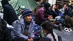 Des migrants se reposent dans un centre logistique au checkpoint "Kuznitsa" à la frontière Bélarus-Pologne près de Grodno (Bélarus)