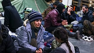 Des migrants se reposent dans un centre logistique au checkpoint "Kuznitsa" à la frontière Bélarus-Pologne près de Grodno (Bélarus)