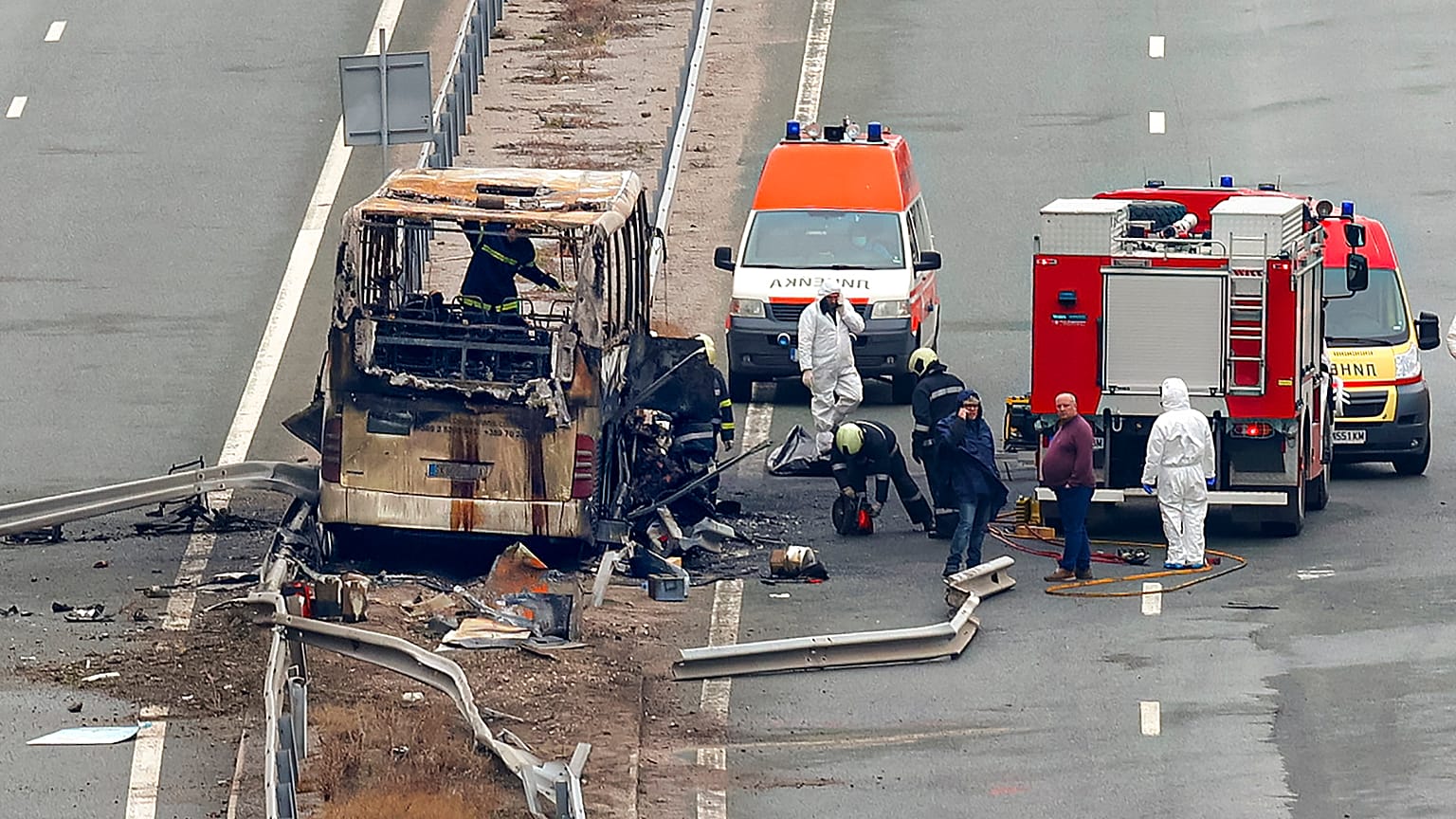 Firefighters and forensic workers inspect the scene of a bus crash on a highway near the village of Bosnek, western Bulgaria, Tuesday, Nov. 23, 2021