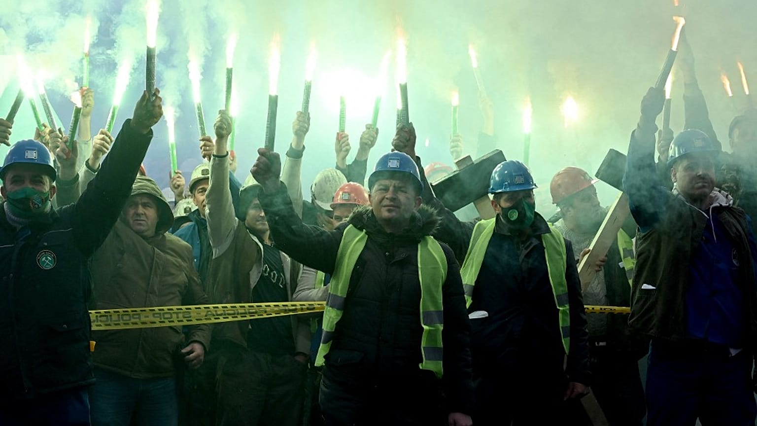 Coal miners hold flares as they gather during protest near government building in Sarajevo, on November 23, 2021.