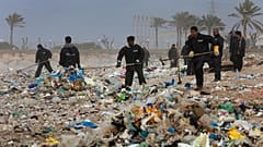 عمال ينظفون الشاطئ من القمامة شمال بيروت، لبنان. 