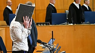 FILE: At the opening of the trial, defendant Taha Al-J. covers his face with a folder in Frankfurt, Germany, Friday, April 24, 2020.