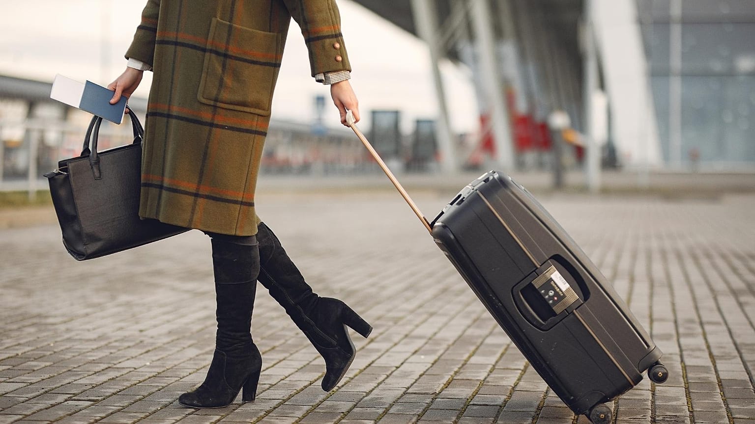 A woman pulls a suitcase 