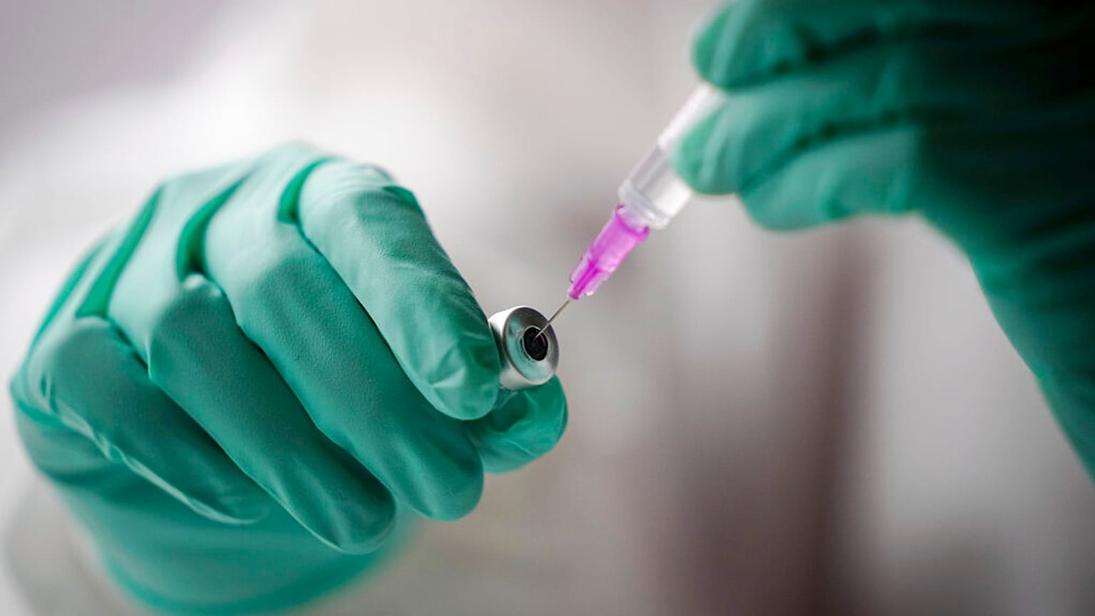 An employee draws up a syringe with the Pfizer vaccine against the coronavirus and the COVID-19 disease at vaccination bus in Berlin, Germany, Tuesday, Nov. 23, 2021.