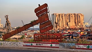 نصب يمثل العدالة يقف أمام آثار الانفجار الهائل في أغسطس/ آب 2020 في بيروت، لبنان.