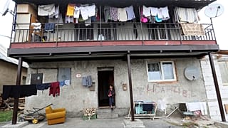 A girl stands outside of a house in a poor Roma settlement near Banska Bystrica, Slovakia.