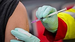 A person is vaccinated with the Pfizer vaccine against the coronavirus and the COVID-19 disease at vaccination bus in Berlin, Germany, Tuesday, Nov. 23, 2021.