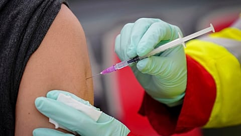 A person is vaccinated with the Pfizer vaccine against the coronavirus and the COVID-19 disease at vaccination bus in Berlin, Germany, Tuesday, Nov. 23, 2021.