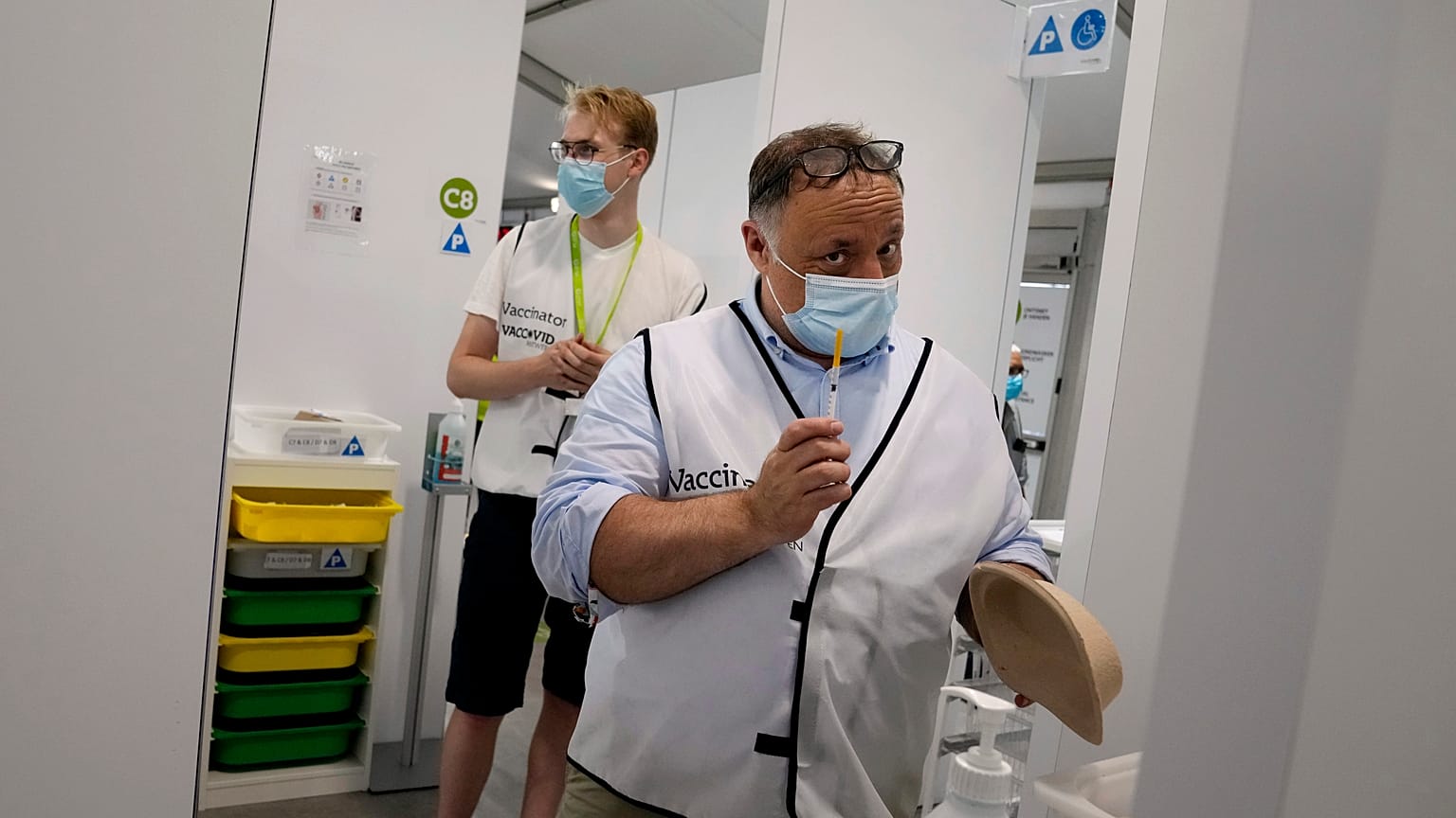 Belgium's chief virologist Mark Van Ranst, right, prepares to administer the Pfizer COVID-19 vaccine at the Vaccine Village in Antwerp, Belgium, June 30, 2021.