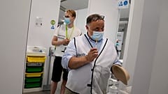 Belgium's chief virologist Mark Van Ranst, right, prepares to administer the Pfizer COVID-19 vaccine at the Vaccine Village in Antwerp, Belgium, June 30, 2021.
