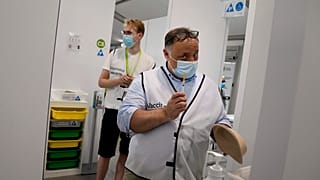 Belgium's chief virologist Mark Van Ranst, right, prepares to administer the Pfizer COVID-19 vaccine at the Vaccine Village in Antwerp, Belgium, June 30, 2021.