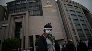 A lawyer arrives at the court in Istanbul Friday, Dec. 18, 2020 to attend the opening hearing of a new trial against jailed Turkish businessman, philanthropist Osman Kavala.