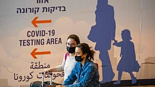 Des voyageurs portant des masques arrivent à l'aéroport Ben Gourion de Tel-Aviv en Israël, 28/11/2021