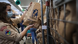 Voluntários trabalham na recolha de alimentos num supermercado, em Lisboa