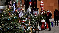 Egy nő nézelődik egy karácsonyi dekorációba öltöztetett mayfair-i borkereskedés előtt Londonban