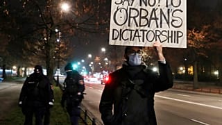 In this Monday, Nov. 30, 2020 file photo, A man protests the policies of Hungarian Prime Minister Viktor Orban during Orban's talks with Poland's Prime Minister Mateusz Morawi