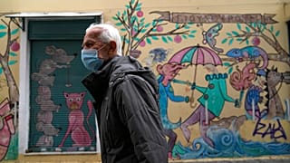 Ein älterer Mann läuft durch die Straßen von Athen mit einer Maske. In Griechenland werden derzeit mehr und mehr COVID-19-Todesfälle gemeldet.