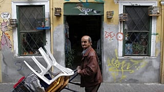 A street vendor pushes a trolley in Athens, Greece