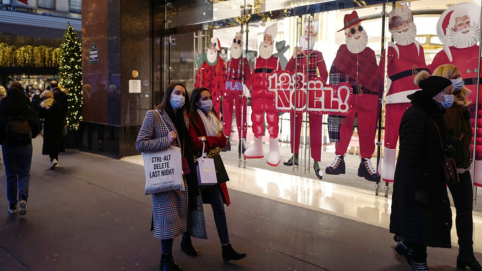 Des passants masqués dans la rue à Paris devant les vitrines de Noël, le 29/11/2021