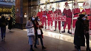 Des passants masqués dans la rue à Paris devant les vitrines de Noël, le 29/11/2021