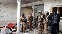Taliban fighters inspect a house after an 8-hour gunbattle