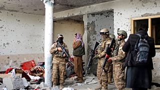 Taliban fighters inspect a house after an 8-hour gunbattle