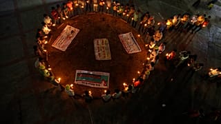 Miembros de una organización no gubernamental forman un lazo, símbolo universal de concienciación y apoyo a las personas que viven con el VIH, 30/11/2021, Ahmedabad, India