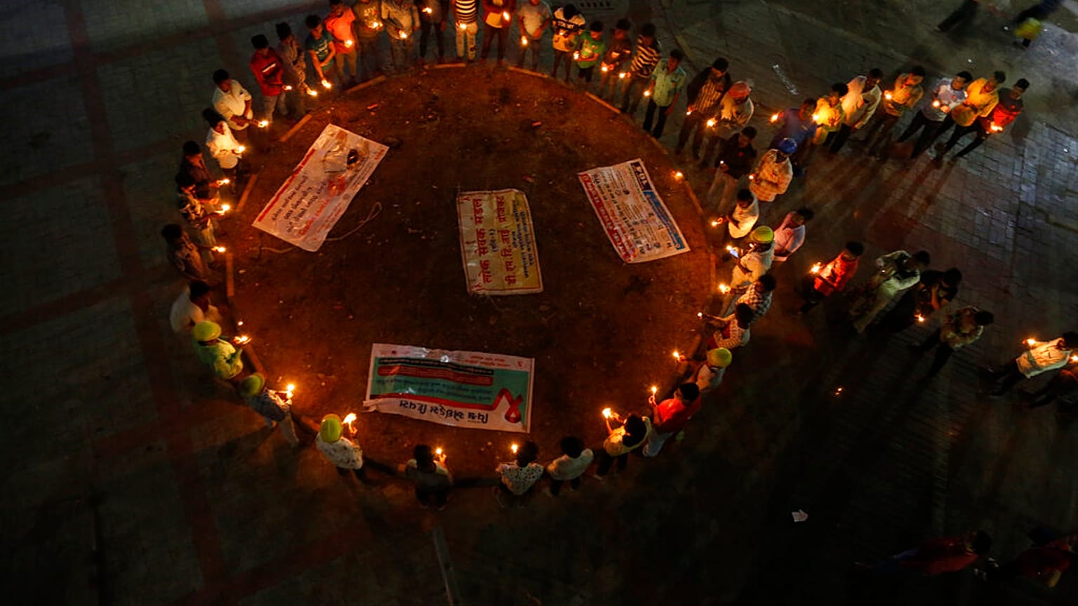 Miembros de una organización no gubernamental confeccionan un lazo rojo, símbolo universal de concienciación y apoyo a los seropositivos