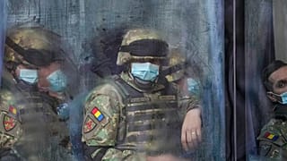 Des militaires roumains dans un bus, en route pour la parade militaire, célébrant les 103 ans de la constitution de la Grande Roumanie, le 1er décembre 2021