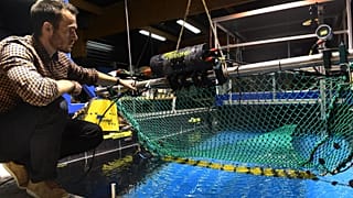 French Ifremer engineer Julien Simon tests a fishing net equiped with a camera to sort fish species on October 5, 2021.