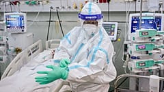 An ICU staff member puts on an extra pair of gloves in the COVID-19 ICU unit of Marius Nasta National Pneumology Institute in Bucharest, Romania, September 2021