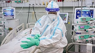 An ICU staff member puts on an extra pair of gloves in the COVID-19 ICU unit of Marius Nasta National Pneumology Institute in Bucharest, Romania, September 2021