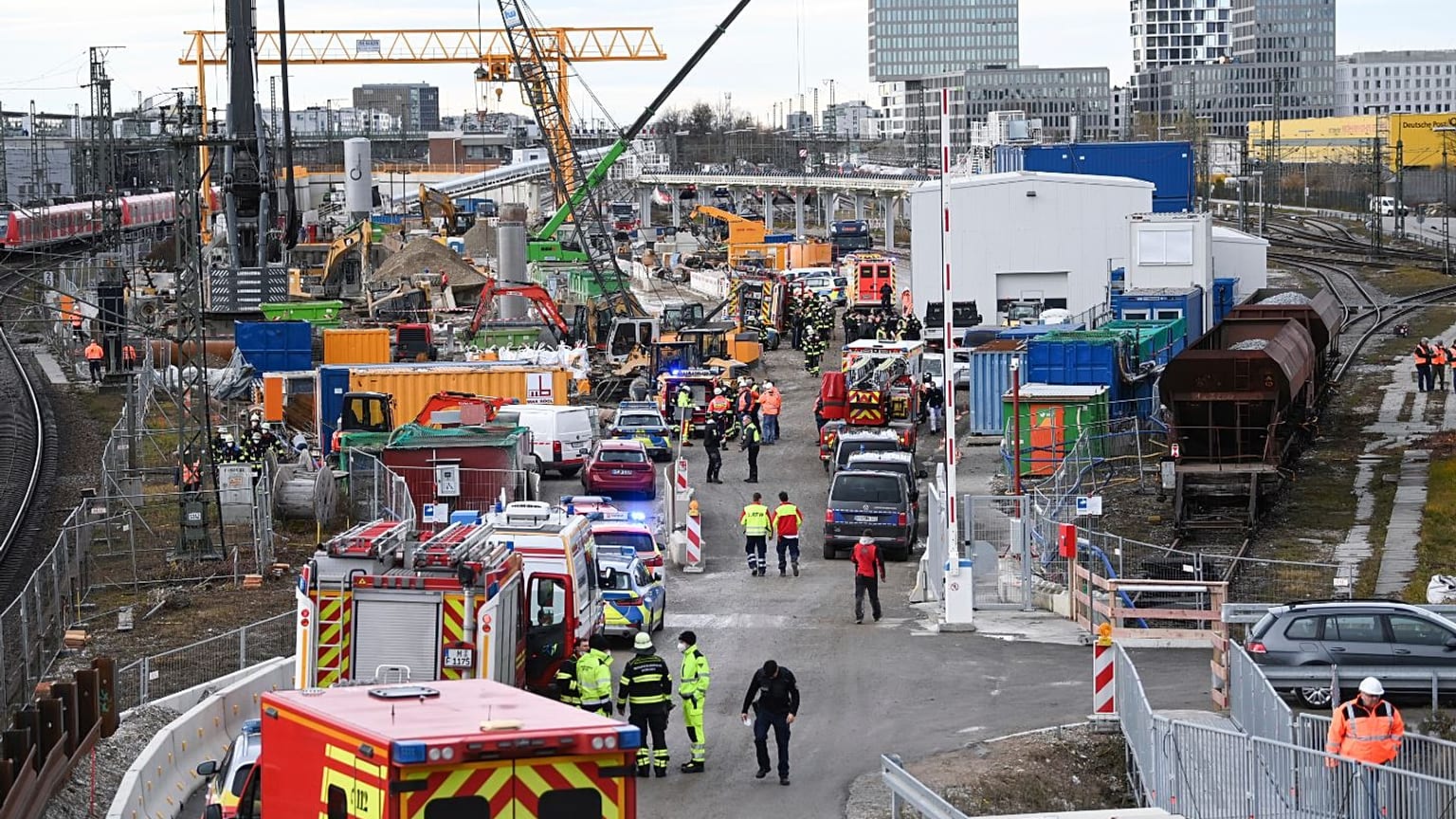 Firefighters, police officers and railway employees stand on a railway site in Munich.